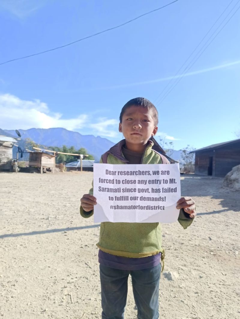 A young boy holds a placard at Thanamir